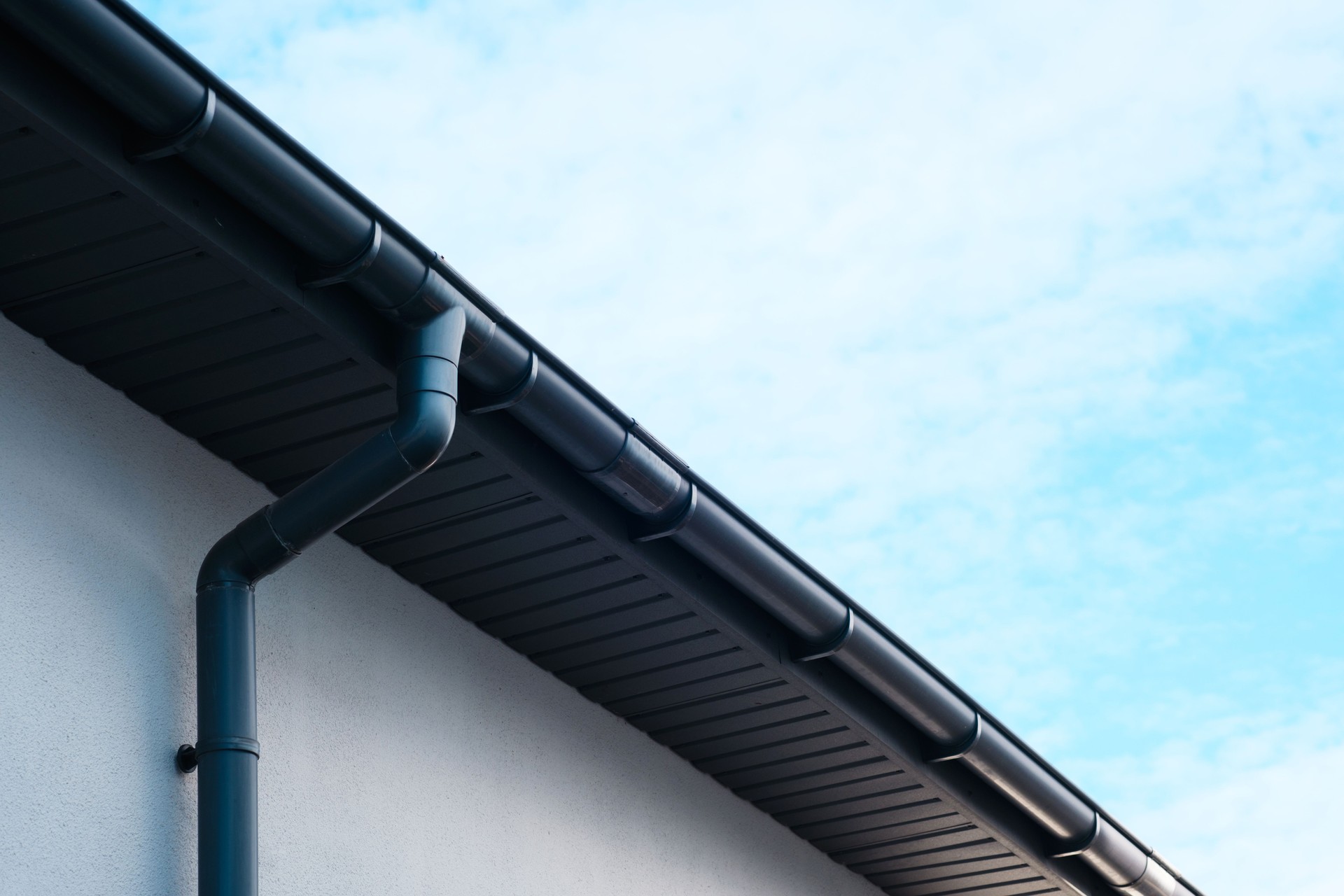 Gutter system on modern building with clear blue sky above