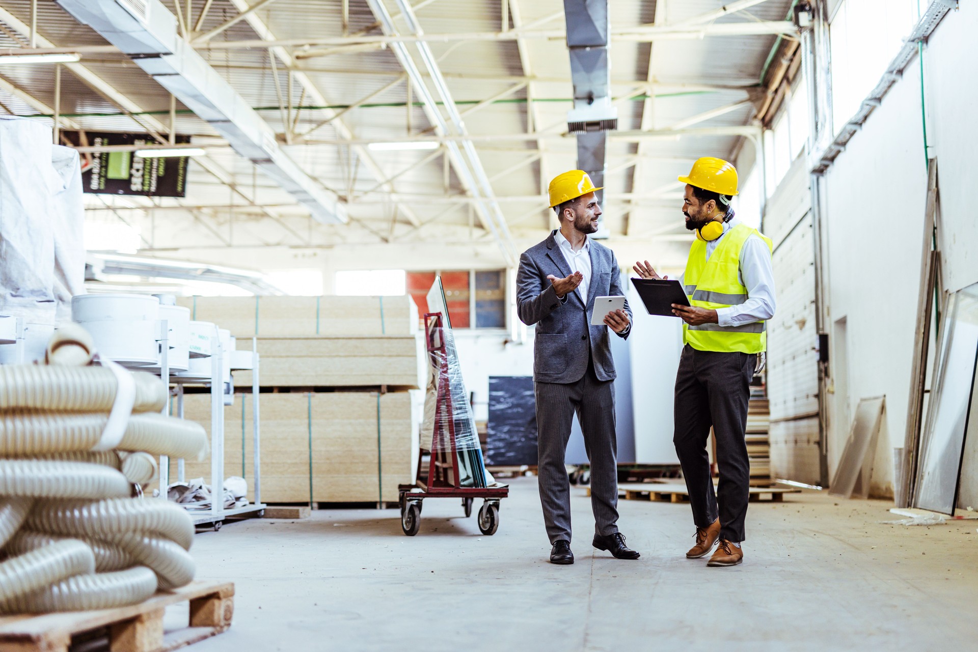 Industrial Engineers Collaborating Inside a Manufacturing Facility Wearing Protective Gear